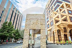 Arch of ancient Bab Alfurdhah Gate surrounded by modern office buildings on the street of Al-Balad, Jeddah, Saudi Arabia photo