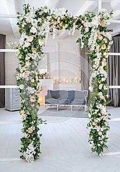 Arch with artificial flowers in the room