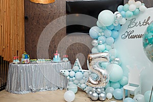 Arch of blue balloons for boy happy birthday party. Number 5 and 1 for two brothers. Festive decorative elements, photo zone