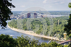 Arch bridge across river during construction in summer, Kyiv, Ukraine