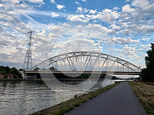 Arch bridge over the Albert canal and towpath on a cloudy day