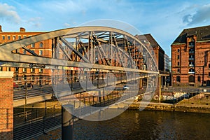 Arch bridge over the canal in Speicherstadt warehouse district at sunset. Hamburg, Germany. Popular tourist destination