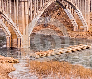Arch bridge with spandrel columns spanning a river