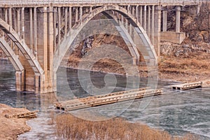 Arch bridge with spandrel columns spanning a river