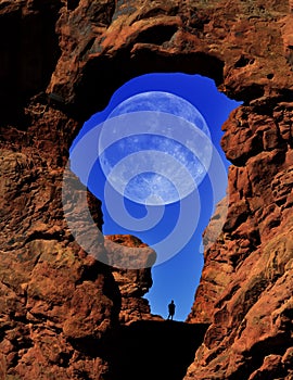 Arch in Canyon Rock Formations Silhouette of Hiker with Full Moon in Sky