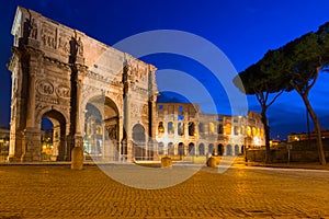 Arch of Constantine and the Colosseum illuminated at night in Rome, Italy