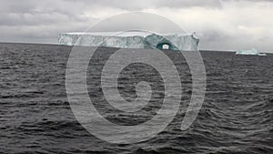 Arch of Darwin unique glacier iceberg in ocean of Antarctica.