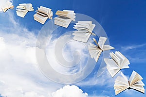 Arch of flying books with blue sky