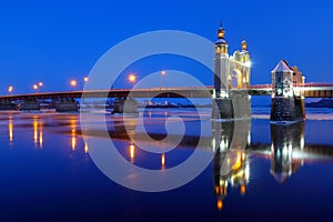 The arch of the Queen Louise Bridge is reflected in the night Neman. Ice drift along the Neman rive