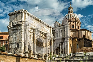 Arch of Septimius Severus and old church on Roman Forum in summer, Rome, Italy photo