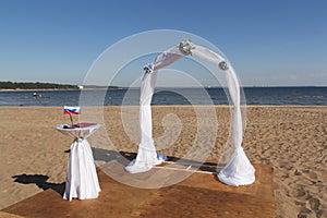 Arch for on-site registration is decorated with flowers and white cloth.