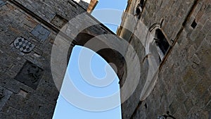 An arch between two ancient historic buildings in the city center of Volterra in Tuscany.
