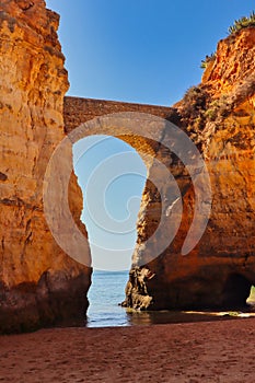 An arch between two rocks at Praia dos Estudiantes in Lagos, Portugal