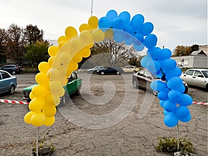 Arch with yellow-blue balloons taken from the side