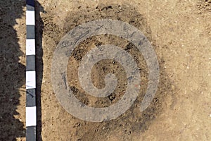 Archaelogical spot in the ground marking of existing some finds tomb or something similar one. Real excavations, digger process.