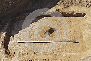 Archaelogical spot in the ground marking of existing some finds tomb or something similar one. Real excavations, digger process.