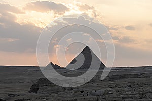 Archaeological complex of Great Egyptian Pyramids is located on the Giza plateau. the night light at sunset. sun sets behind the