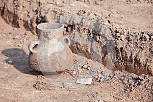 Archaeological excavations. Found artefact, aged damaged ceramic jar on the ground.