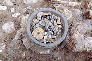 Archaeological excavations. Human remains bones of skeleton  in the ground and little found in the tomb artefacts in center bea