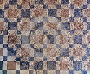 Archaeological remains of Roman mosaic with geometric figures, red and blue squares forming a checkerboard pattern on the floor of