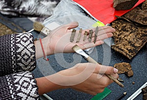 Archaeologist holds on his hand several different ancient arrowheads