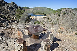 archaic table with the background of the Pego dam inserted between mountains of the Portuguese village of Penha Garcia