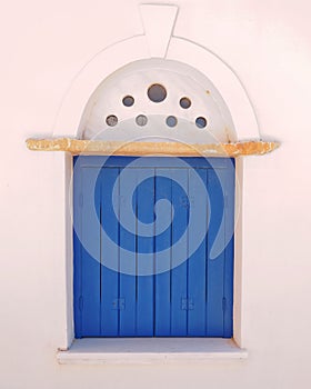 Arched decorated blue window in Mykonos island, Greece