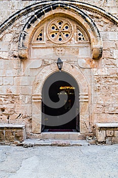 Arched entrance to the old church. Inside lit candles and lamps