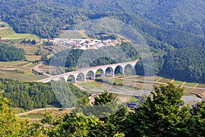 Arched flyover for two-lane roadway in forested countryside