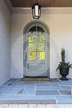 Arched front door with light and plant