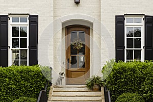Arched front door with statue and shrubs
