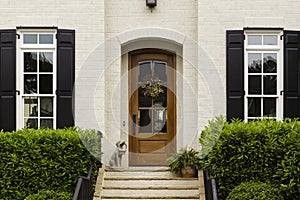 Arched front door with statue and shrubs photo