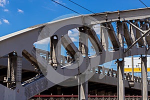 Arched metal structure of the railway bridge against the blue sky