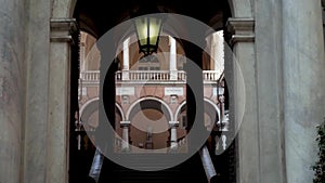 Arched passage to old architectural building. Action. Arched passages among open halls of old building with columns