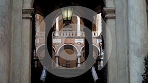 Arched passage to old architectural building. Action. Arched passages among open halls of old building with columns