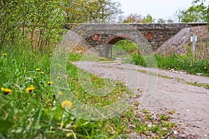 An arched railway bridge over the road, old stone viaduct