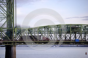 Arched section of bridge with support and moving red semi truck