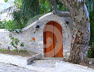 Arched stone courtyard entry wall with arched wooden door