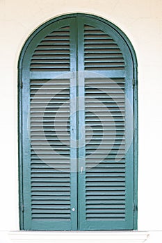 Arched window with blue shutters