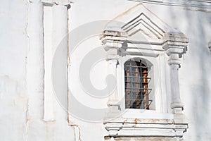 Arched window in a brick white-stone wall of a temple with a stone platband, background