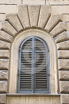 Arched window closed shutters, Italy.