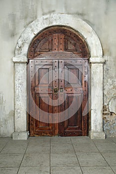 Arched wooden door in a stone wall
