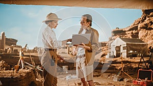 Archeological Digging Site: Two Great Archeologists Stand in Tent Work on Excavation Site, Use