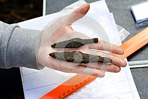 Archeology: rusty arrowheads of medieval arrows lie on the hand of a scientist