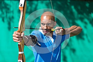 Archer aiming at target with bow and arrow photo