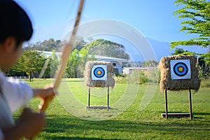 Archer aiming at target in open field