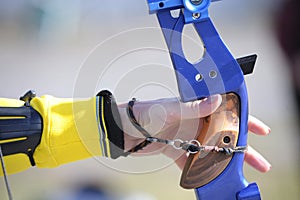 An archer hand pulling the string back of bow