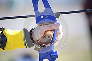 An archer hand pulling the string back of bow