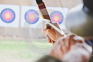 Archer holds his bow aiming at a target