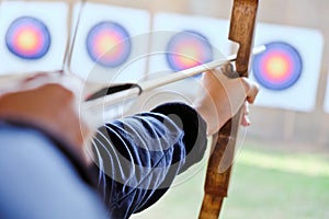 Archer holds his bow aiming at a target